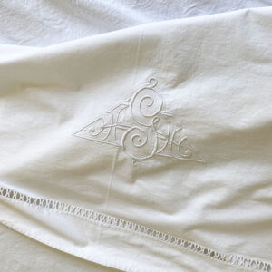 Détail drap ancien en toile épaisse en métis coton et lin, avec motif en triangle brodé en point feston et jour échelle tout au long de la bordure.