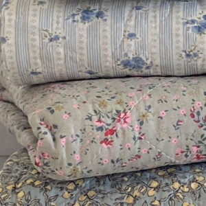Détail motif Angèle de la Courtepointe ou plaid en coton matelassé cocooning surpiqué finition quilt. Motif fleuri fond vert sauge qui évoque les beaux jours ou les hivers cosy du style scandinave Hygge