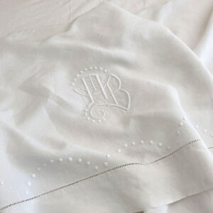 Drap ancien brodé à la main, issu d’un trousseau de mariage de la fin du XIXe siècle, en belle toile ancienne métis lin/coton, orné d’un monogramme et de plumetis.