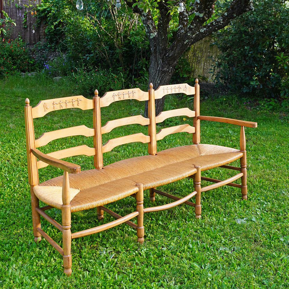 Radassier ou banquette provençale à 3 places, en bois massif avec assise paillée traditionnelle avec dossier sculpté d'une farandole d’Arlésiennes et de gardians pour les amateurs de Provence, de Camargue et d'Arles conjugués